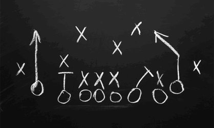 A gameplan with Xs and Os in white chalk on a black chalkboard